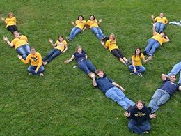 Students forming WV in by laying in the grass